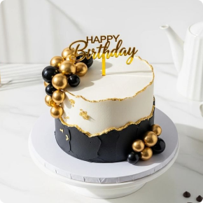 A black-and-gold birthday celebration cake
